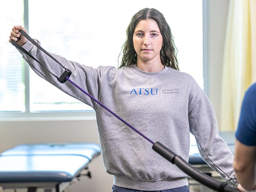 ATSU DAT student performing an exercise using a stretching band