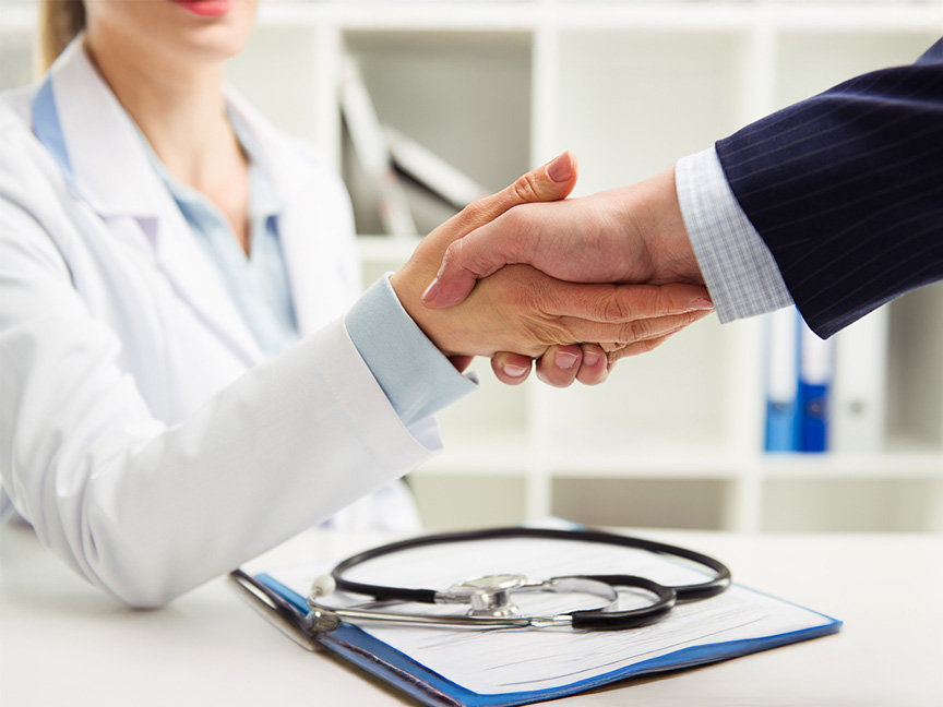 Healthcare providers shaking hands, symbolizing collaboration and professionalism in the healthcare field.