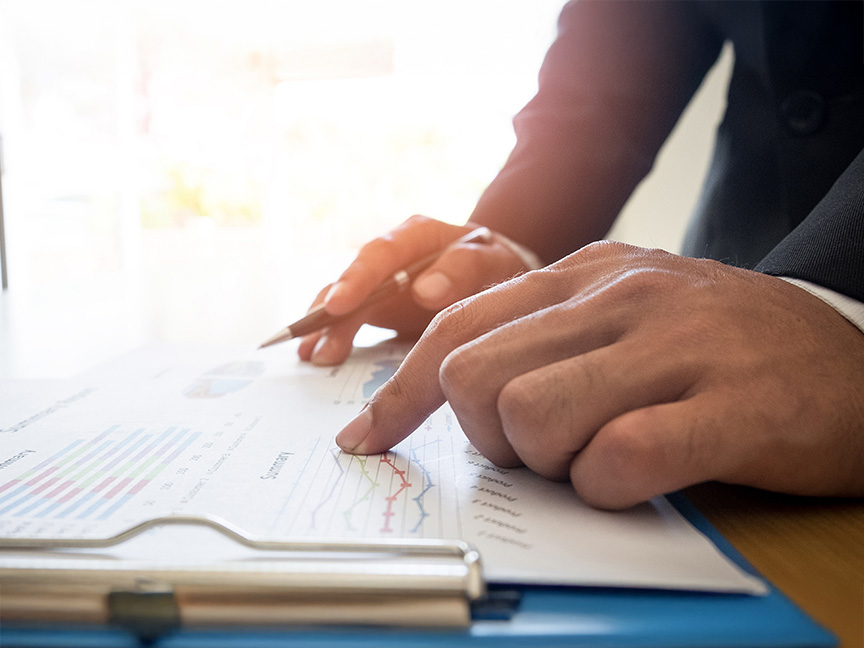 Hand pointing at a chart, highlighting data analysis and decision-making in a healthcare or business setting.