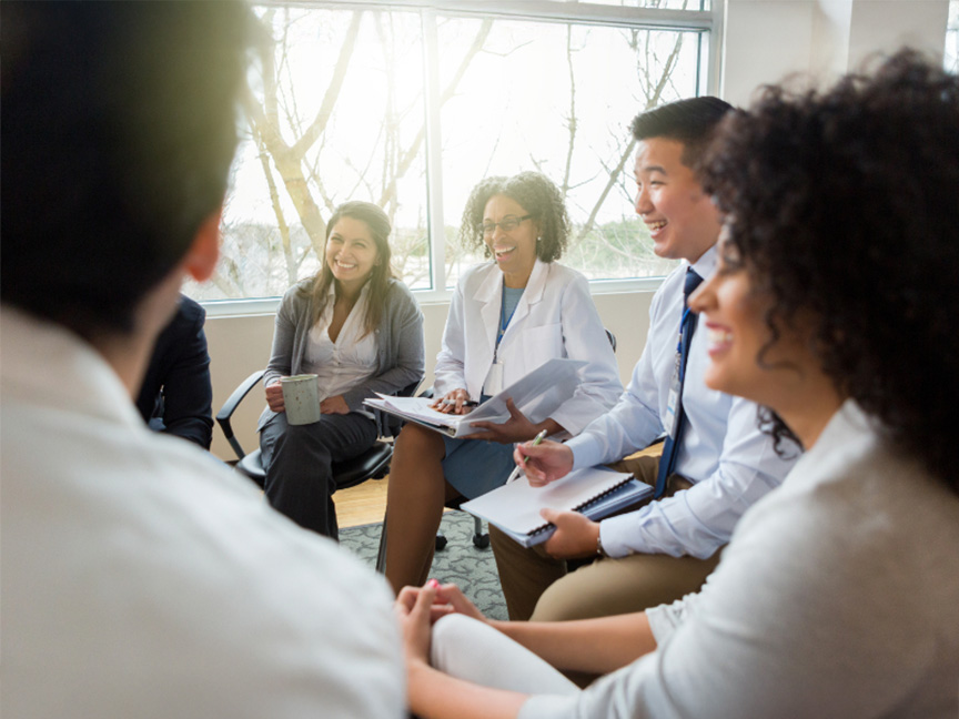 MEd students collaborating in a circle, emphasizing teamwork and active learning in the Master of Education program.