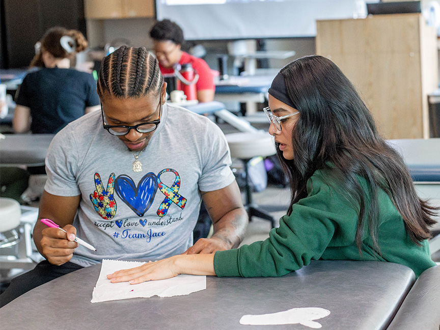 Two Entry-Level OTD students collaborating on an assignment, showcasing teamwork and problem-solving in occupational therapy education.