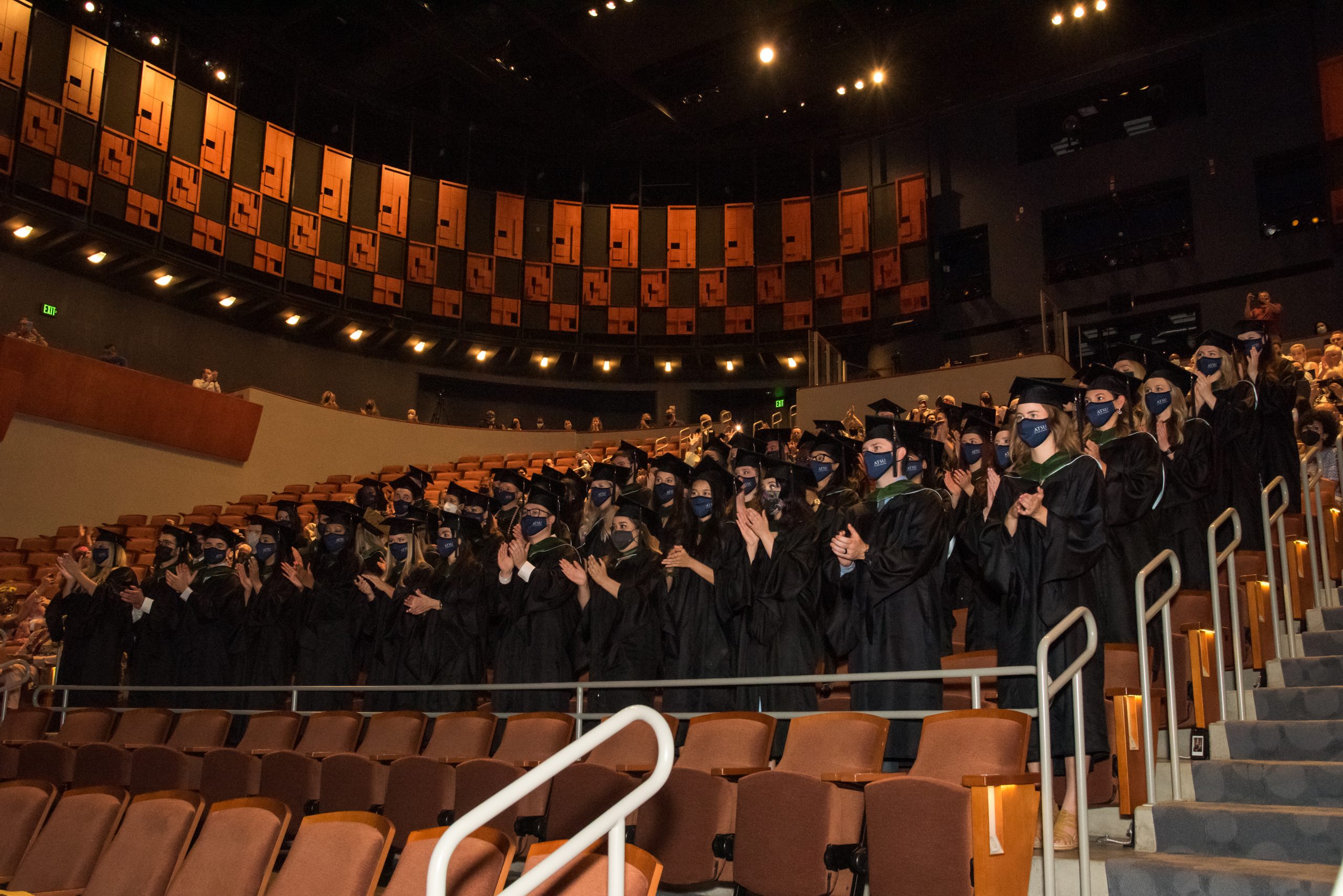 Graduates stand and applaud during the ATSU-ASHS residential Physician Assistant program commencement ceremony.