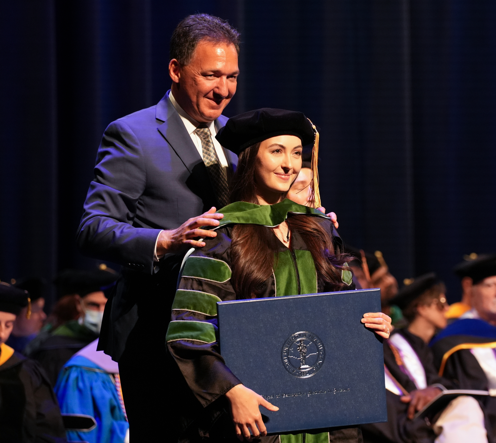 McKenna Yost, DO, ’24, is hooded by Dr. Darin Vercillo.