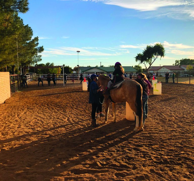 hippotherapy with child on horse and two side walkers at Arizona ranch